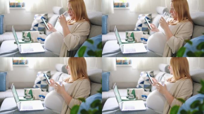 孕妇喝水，在家用笔记本电脑工作