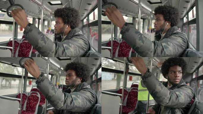 在公交车上，黑人男乘客正在听音乐