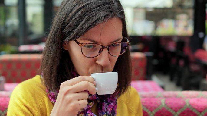 伊斯坦布尔，一名年轻女子在路边咖啡馆喝咖啡