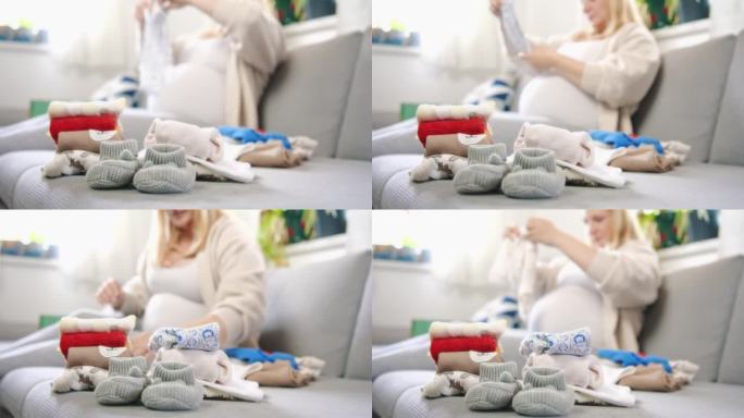 孕妇在客厅沙发上叠婴儿衣服