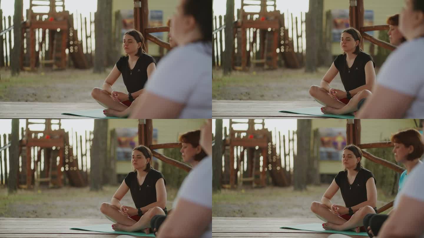 一群不同的女性在夏令营练习瑜伽，坐莲花位和冥想