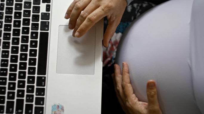 从上图看，一位孕妇正在使用笔记本电脑