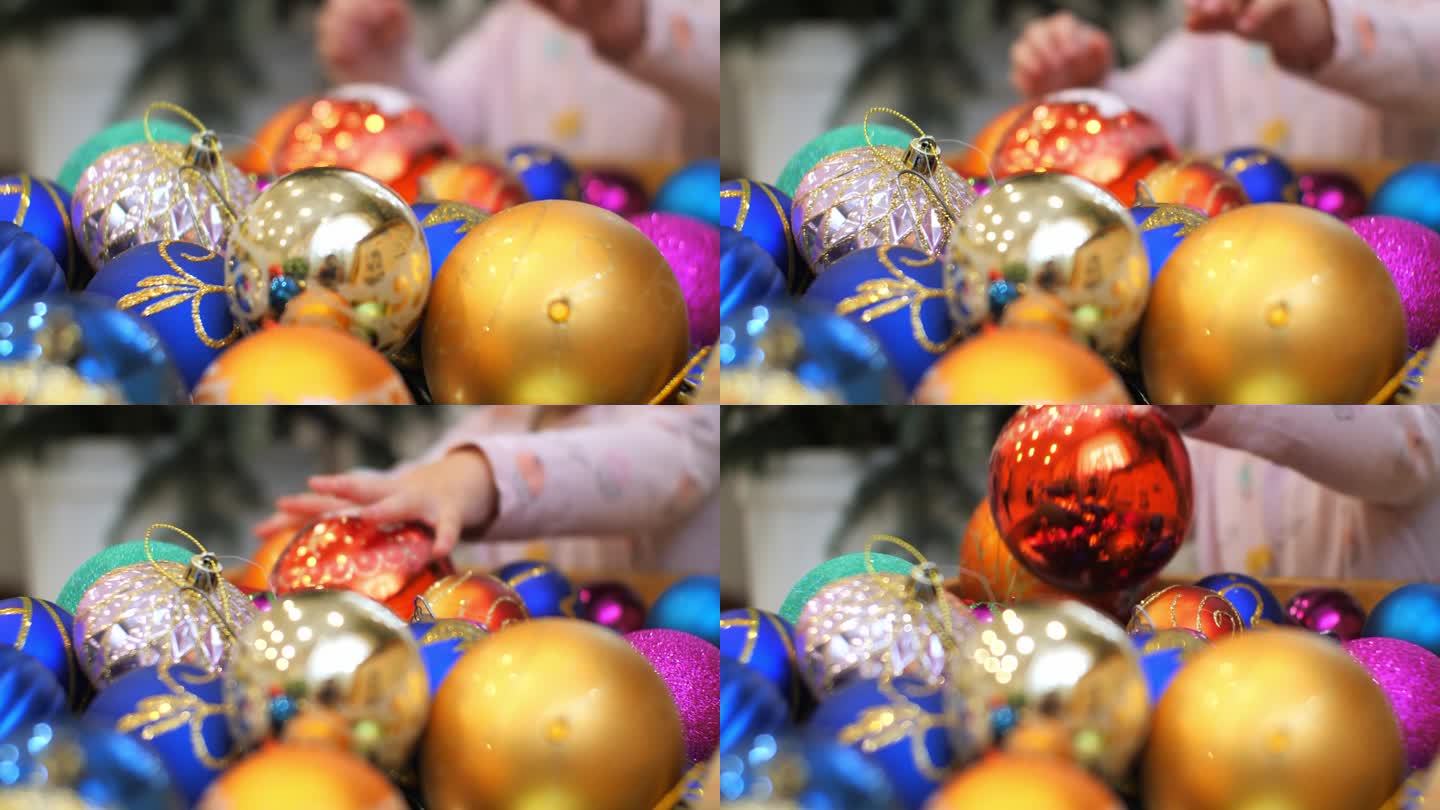 孩子们的手从玩具盒里拿出新年球挂在圣诞树上。一个孩子欢欢喜喜地迎接新年，热情地拆开圣诞树上的一盒装饰