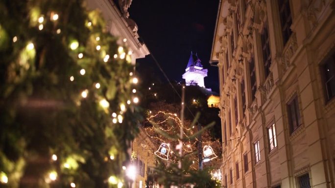 从奥地利格拉茨的灯火辉煌的城市中，手持低角度拍摄著名的钟楼