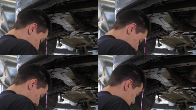 机械师把防冻液从车底下面的软管里放出来。