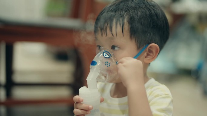亚洲男孩接受雾化吸入治疗感冒和支气管炎。