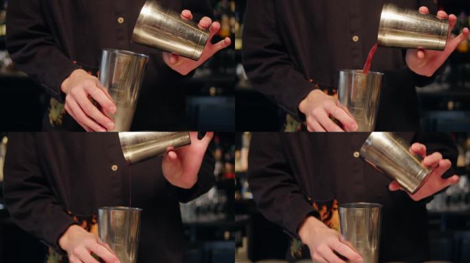 年轻的调酒师在酒吧用摇酒器调制鸡尾酒。一个人在吧台后面调制鸡尾酒