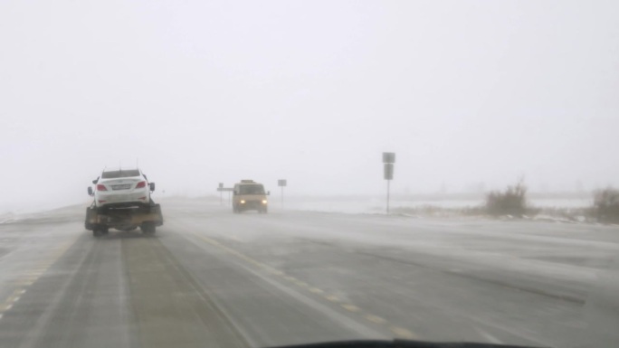 危险的道路与冰和暴风雪，从汽车的拖车疏散车辆。危险条件下，汽车疏散突出了结冰道路的危险。拖车在危险的