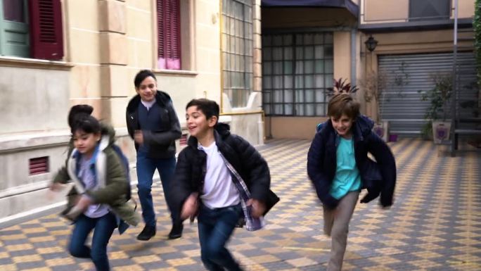 快乐的孩子们在放学后互相赛跑，跑向门口