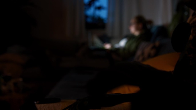 孕妇晚上在黑暗的客厅里使用笔记本电脑