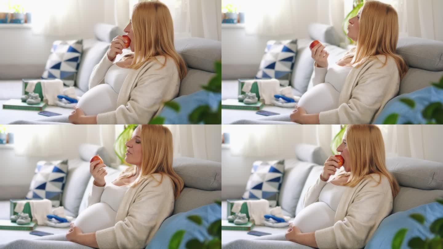 孕妇在家里客厅的沙发上吃苹果