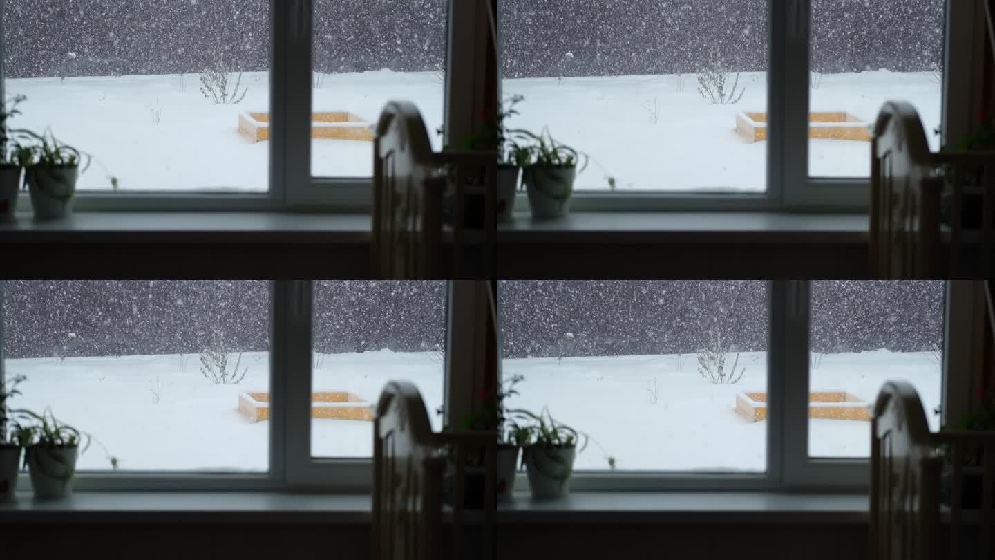 窗外的冬日景色。外面正在下雪。雪花飘落的慢动作。窗外冬天的景色。如画般的圣诞节气氛。假期。暴风雪。