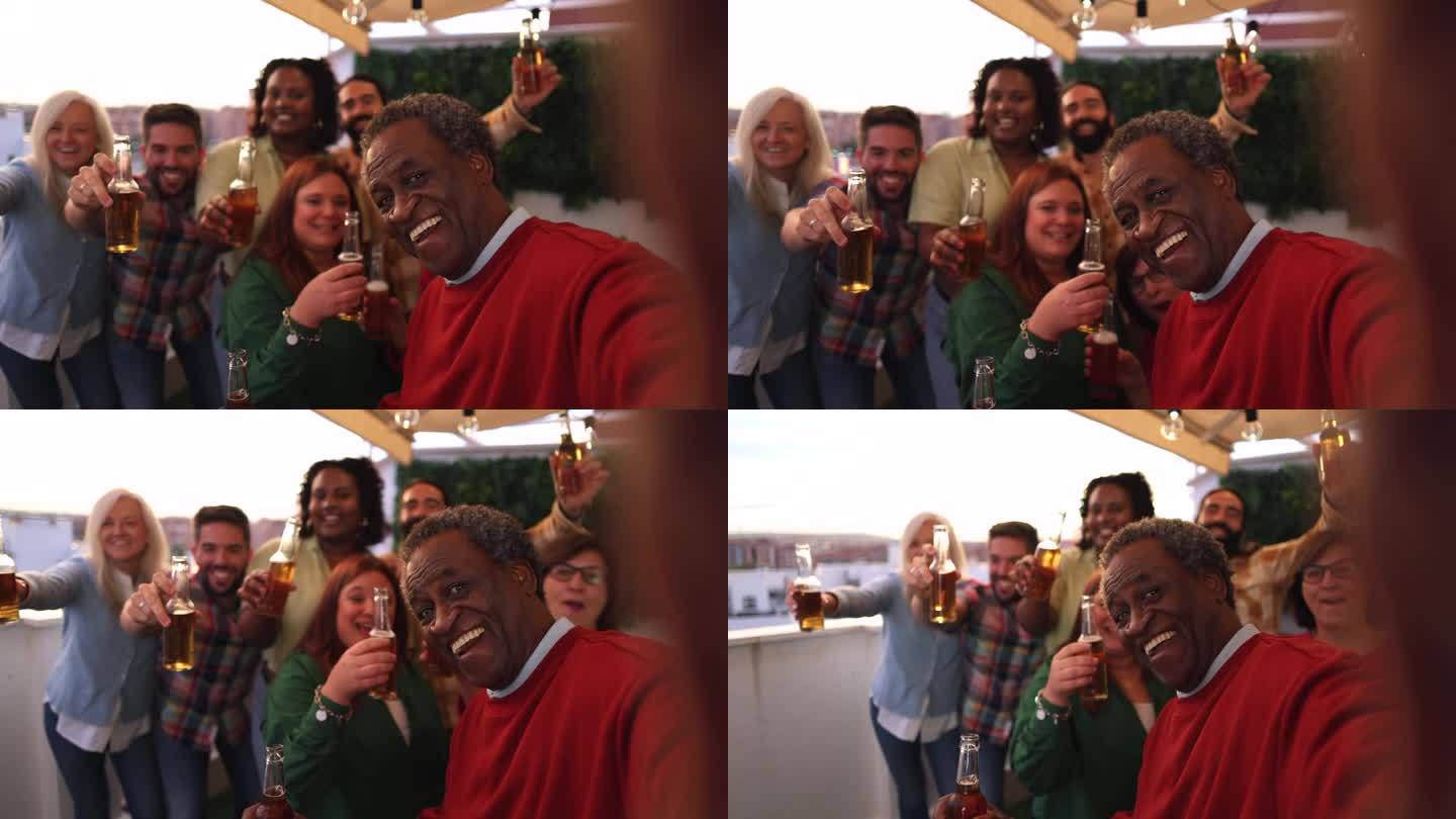 一群不同世代的多种族朋友用啤酒庆祝屋顶派对——社交媒体自拍