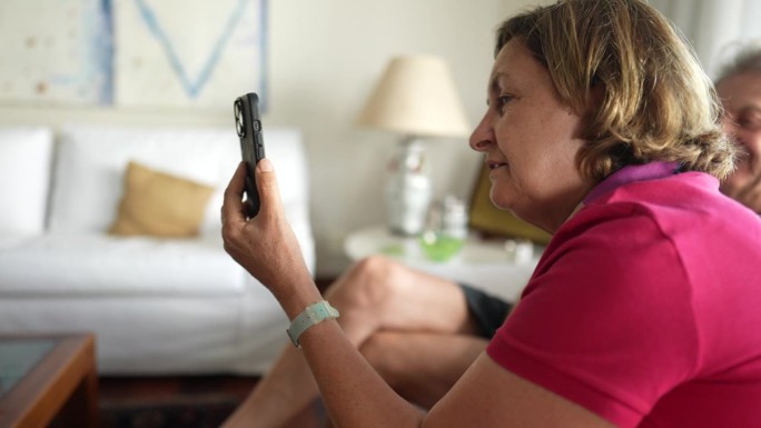 奶奶在家里拿着智能手机和亲人视频通话