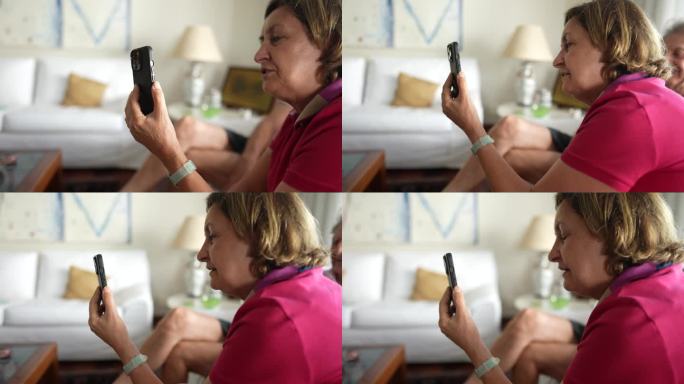奶奶在家里拿着智能手机和亲人视频通话