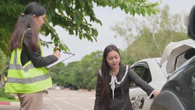 亚洲女司机与年轻女车险官员谈话同意的意外索赔将被评估和处理。