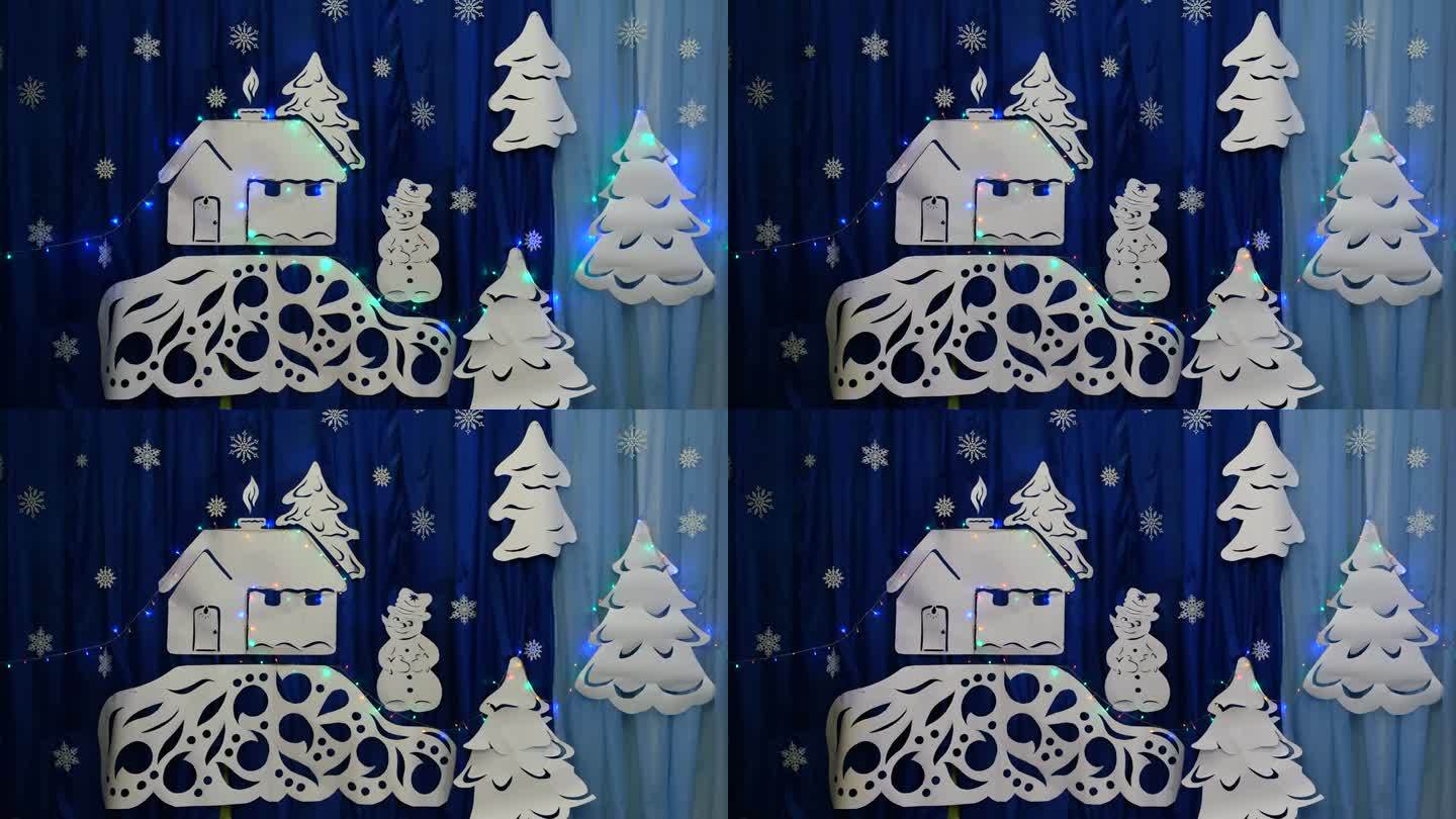 用自己的双手制作新年背景。用纸剪成的白色房子上闪闪发光的花环。