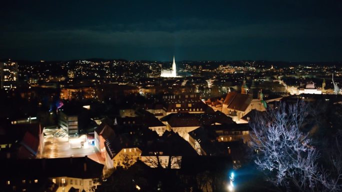 在奥地利施蒂里亚地区的格拉茨，夜间被照亮的城市景观的空中封锁拍摄