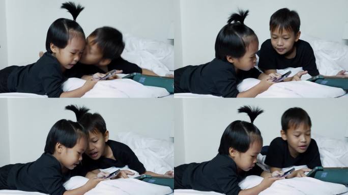 亚洲兄弟男孩躺在床上开心地在家玩手机，家庭纽带概念。