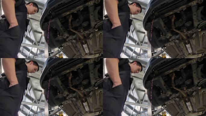 机械师把防冻液从车底下面的软管里放出来。