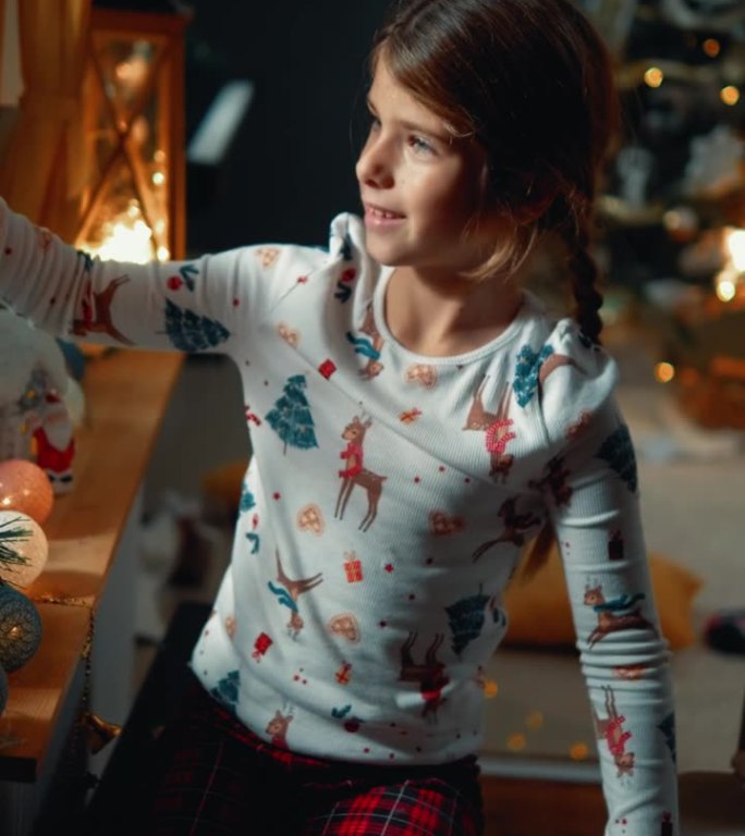晚上，一个小女孩在装饰好的客厅里拿着烟花庆祝圣诞节