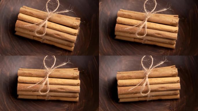 肉桂棒用天然的绳子系在厨房棕色的木碗里。圣诞节必备食材。旋转