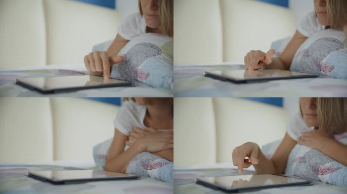 SLO MO的特写，剪短的女人躺在家里的床上使用数码平板电脑