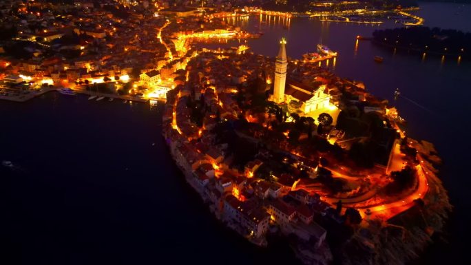 罗维尼(Rovinj)风景如画的半岛在夜晚变得生机勃勃，以坐落在山顶上的迷人教堂为特色