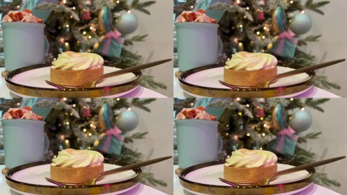 柠檬挞和南瓜拿铁的背景，一棵圣诞树与蓝色和粉红色的玩具美味的食物美味的绿树金色的边缘附近的一个白色盘