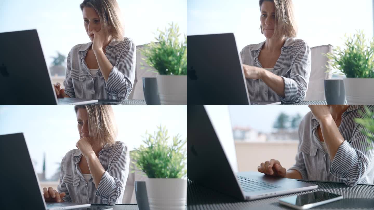 中年成年女性坐在露台上用笔记本电脑工作