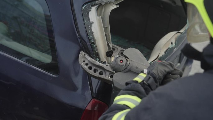 一支技术娴熟的消防队员使用专业工具和快速反应成功救出被困在汽车中的人，展示了他们在高风险救援行动中的