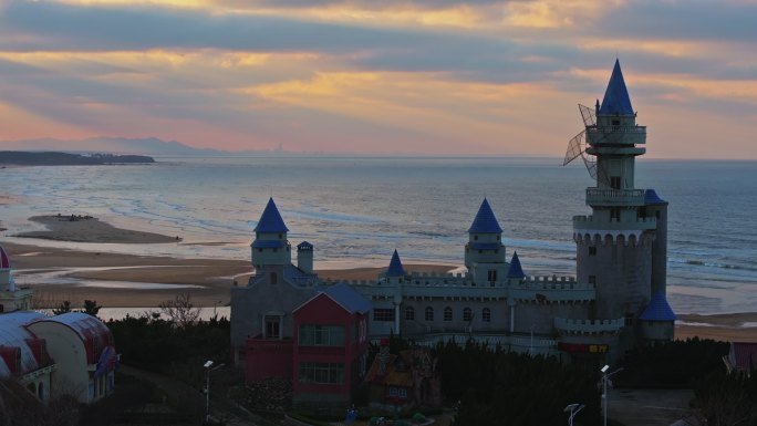 航拍威海影视城童话城堡海岸沙滩晚霞丁达尔