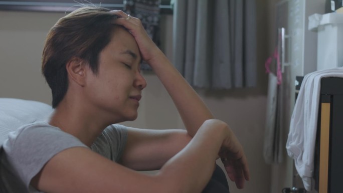 遭受虐待、暴力和离婚后果的亚洲女性的特写，她在卧室地板上嚎啕大哭，表达着心碎和绝望的痛苦。