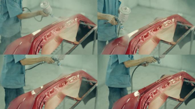 精密汽车涂装:亚洲技师美化保险杠和车身。