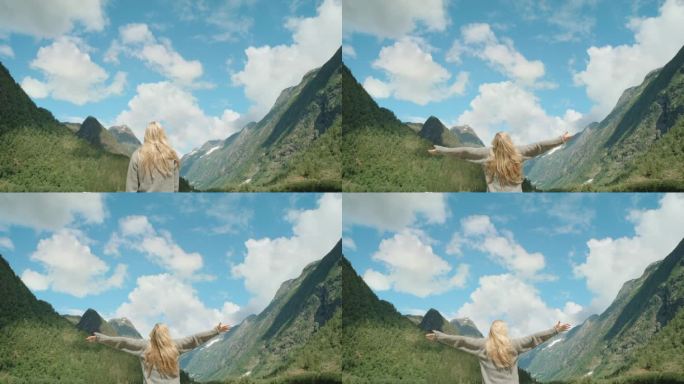 女人举起手臂在山顶上看风景举起手臂庆祝风景享受假期旅行冒险自然挪威