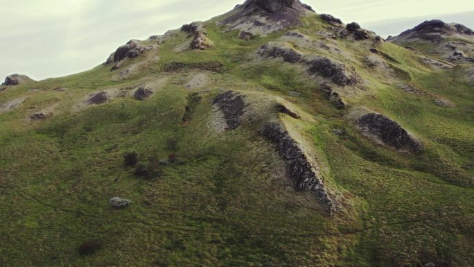 航拍小草青苔青绿的山顶，冰岛夏季日落时金色温暖的傍晚，无人驾驶的轨道