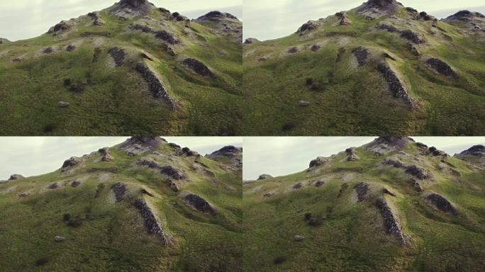 航拍小草青苔青绿的山顶，冰岛夏季日落时金色温暖的傍晚，无人驾驶的轨道