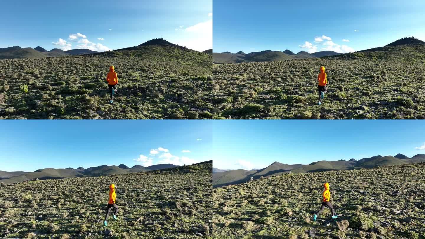 空中拍摄的女子越野跑运动员在高海拔山顶的慢动作