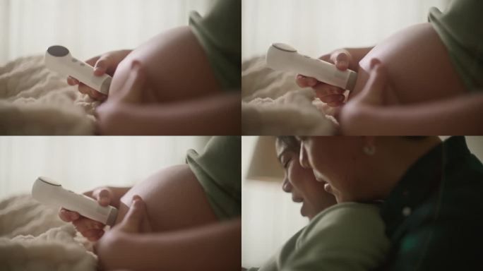 幸福的新婚夫妇亚洲恋人使用个人超声波扫描仪检查和听天使的声音，从婴儿怀孕在妈妈的肚子在家里的床上