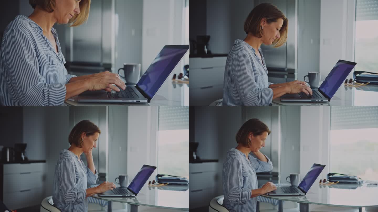 放大手持镜头的女人在笔记本电脑上打字，而从家里的桌子上工作