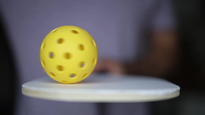 塑料球在一个泡菜球拍上以慢动作旋转