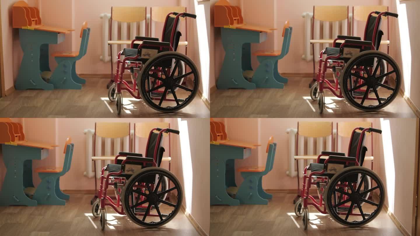 一辆儿童轮椅矗立在学校走廊的中央，背景是一张课桌。儿童康复中心。