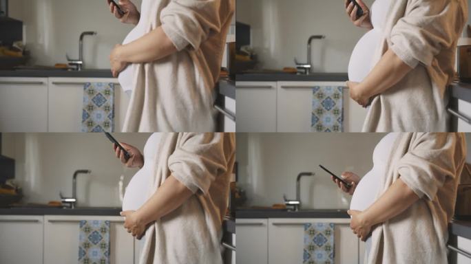 孕妇在厨房按摩肚子