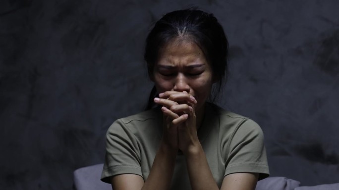 一个女人躺下，眼里含着泪，并不快乐。抑郁和消极情绪问题精神健康问题被性骚扰。