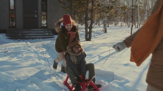 快乐的男孩在冬天的雪橇上