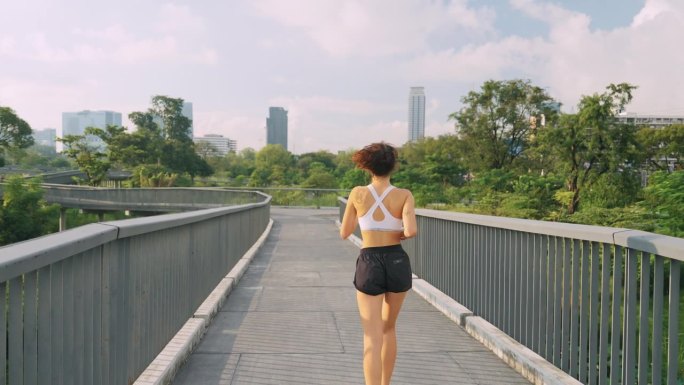 一个女人在大城市市中心茂密的树叶中奔跑