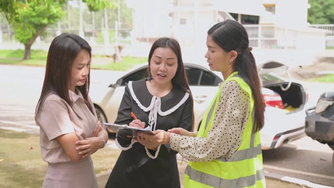 亚洲女司机与年轻女车险官员谈话同意的意外索赔将被评估和处理。