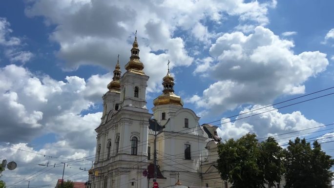 在乌克兰索博纳亚大街中央广场，文尼察市教堂的金色圆顶与蓝天的背景，白色的墙壁