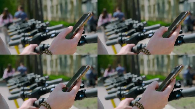 女性手持手机，在外面用app租滑板车的特写。不认识的成年女性通过智能手机应用租用生态摩托车。