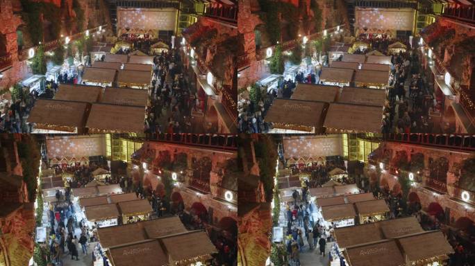 高角度手持拍摄的人群在圣诞市场夜间在格拉茨，施蒂里亚地区，奥地利